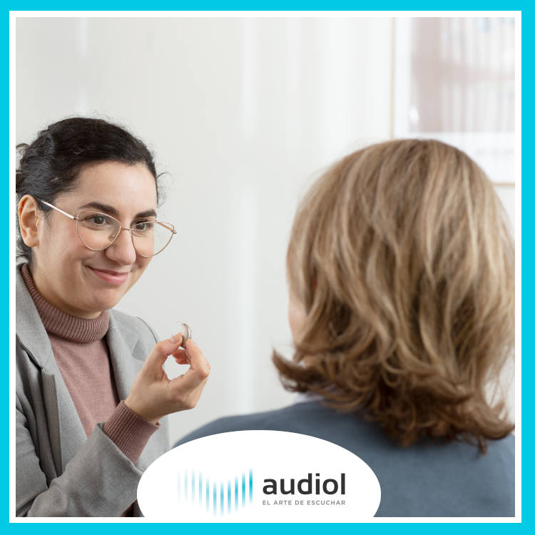 Mujer enseñando audífonos Oticon